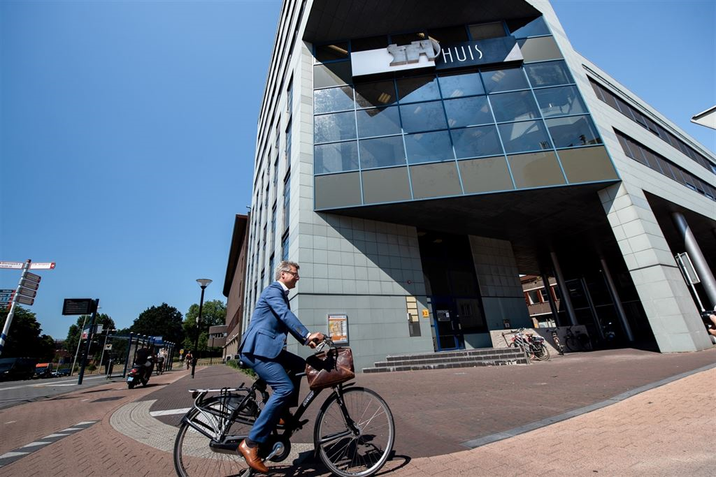  Tekst bij foto voor slechtzienden: Foto van fietser die in de Molenstraat rijdt langs het Stadhuis van Amersfoort. 